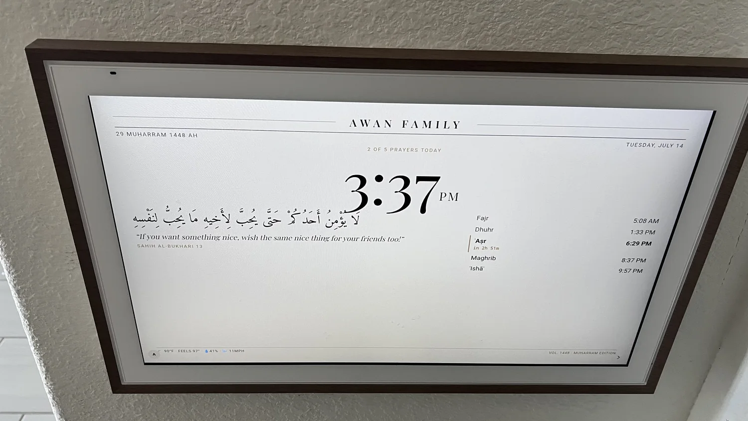 The AdabStars board on the wall showing the prayer-time screensaver: the family header, today's five prayer times with Asr next, the Hijri date, and a hadith
